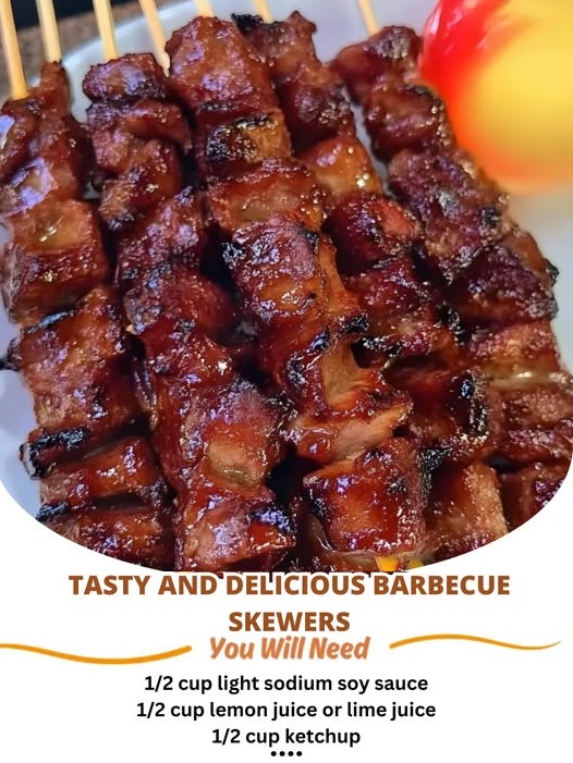 Grilled barbecue skewers with juicy meat and vegetables on a wooden board, garnished with herbs.