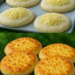 A rustic loaf of golden-brown cheesy bread with a crisp crust and melted cheese pockets visible on the surface.