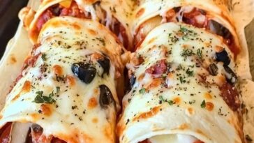 Golden-brown baked pizza wraps filled with cheese, pepperoni, and tomato sauce, served on a plate.