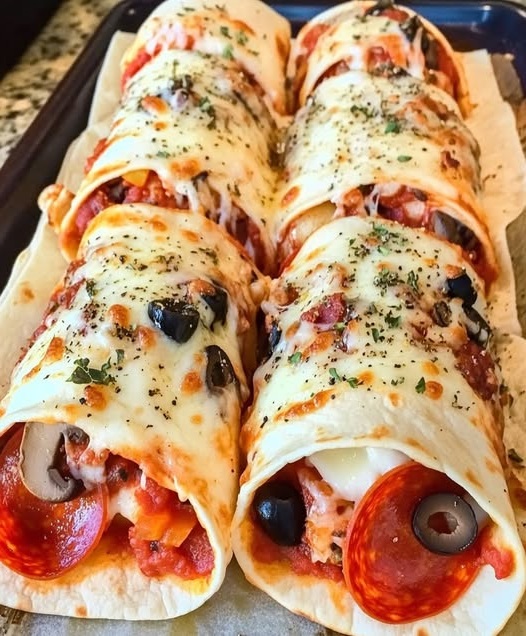 Golden-brown baked pizza wraps filled with cheese, pepperoni, and tomato sauce, served on a plate.