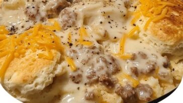 A hearty slice of biscuits and gravy hashbrown casserole with golden biscuits, creamy sausage gravy, and crispy hashbrowns.