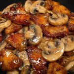 Stir-fried black pepper chicken with sliced mushrooms and bell peppers in a glossy savory sauce, served over white rice.