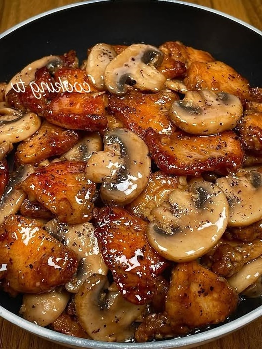 Stir-fried black pepper chicken with sliced mushrooms and bell peppers in a glossy savory sauce, served over white rice.