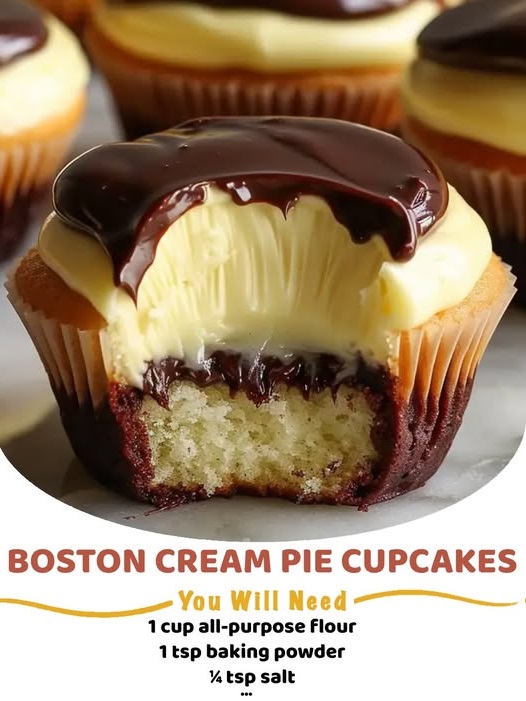 Cupcakes filled with creamy vanilla custard, topped with a glossy layer of rich chocolate ganache, and arranged on a serving platter.
