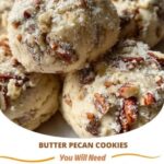 Freshly baked butter pecan cookies with golden brown edges and chopped pecans on top, arranged on a cooling rack.