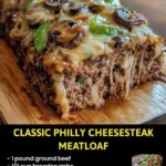 Sliced Philly cheesesteak meatloaf topped with melted cheese and sautéed peppers and onions.