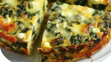 A golden, crustless quiche with visible layers of wilted spinach and creamy cottage cheese, sliced and ready to serve.
