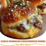 Golden-brown garlic parmesan cheeseburger bombs cut open to reveal melted cheese, seasoned ground beef, and soft dough.