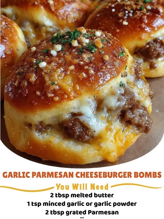 Golden-brown garlic parmesan cheeseburger bombs cut open to reveal melted cheese, seasoned ground beef, and soft dough.