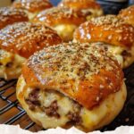 Golden, bite-sized cheeseburger bombs stuffed with melted cheese and seasoned beef, coated in garlic butter and parmesan, ready to be enjoyed.