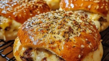 Golden, bite-sized cheeseburger bombs stuffed with melted cheese and seasoned beef, coated in garlic butter and parmesan, ready to be enjoyed.