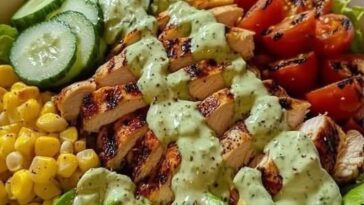 A fresh grilled chicken and avocado salad bowl with mixed greens, cherry tomatoes, and a light dressing.