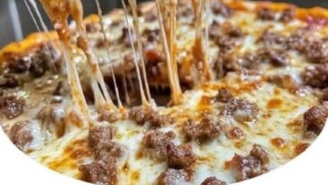 A hearty slice of meat lovers pizza casserole with layers of pasta, marinara sauce, melted cheese, pepperoni, sausage, and ground beef.