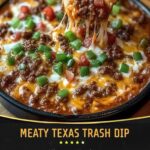 A hot, bubbling dish of Meaty Texas Trash Dip with layers of melted cheese, seasoned ground beef, refried beans, and topped with jalapeños, served with tortilla chips on the side.