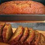 A thick, moist slice of banana bread with a golden-brown crust, served on a plate with a pat of butter melting on top.