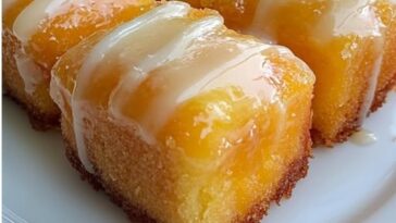 Golden Twinkie-style cakes filled with peach cobbler cream and drizzled with glaze, topped with bits of peach and cake crumbs.