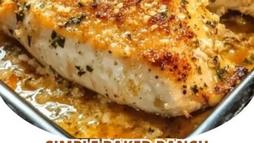 Juicy baked ranch chicken breasts garnished with herbs, served in a baking dish with a golden, seasoned coating.